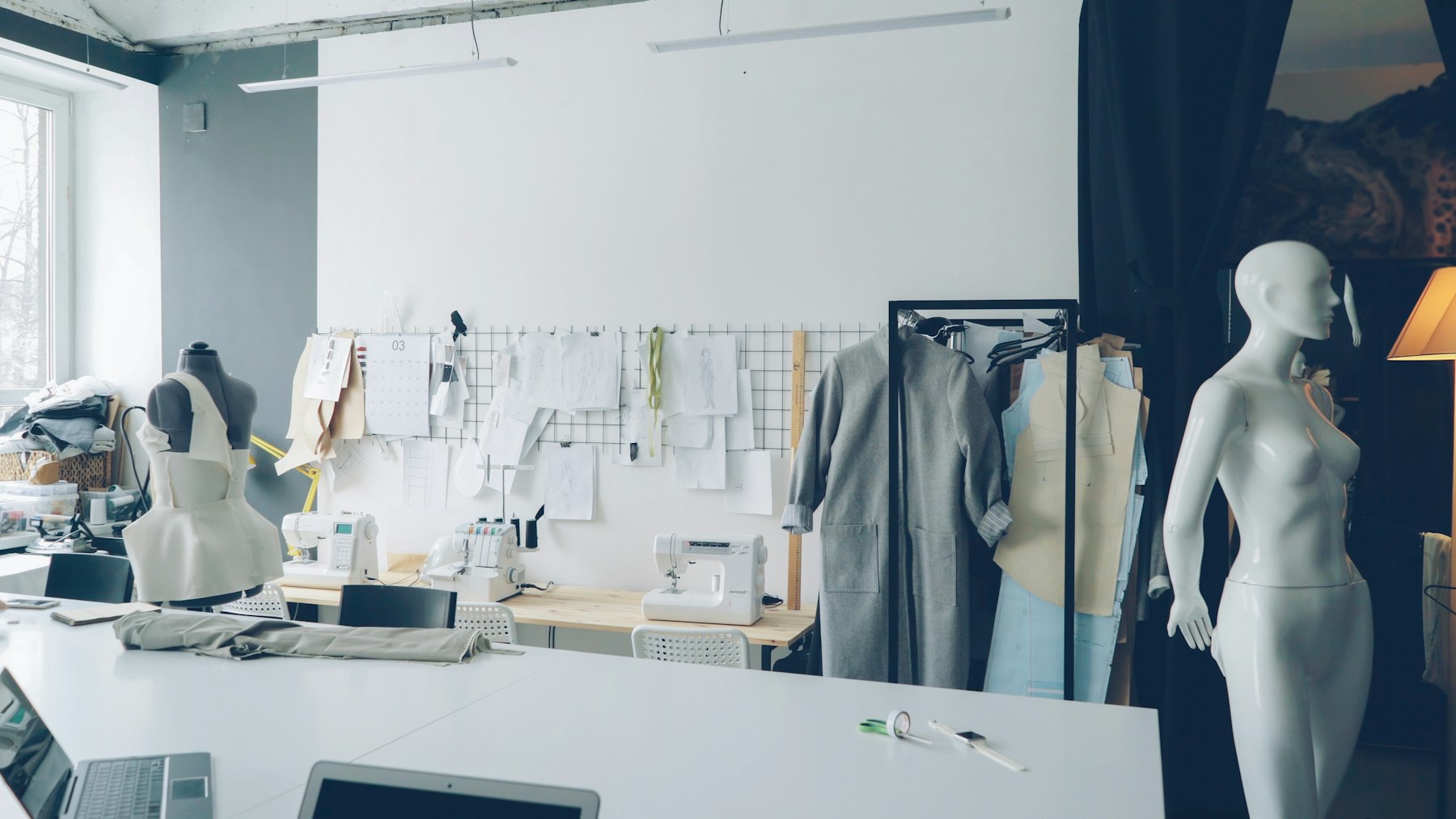 Fashion design studio with sewing materials, sketches and mannequins