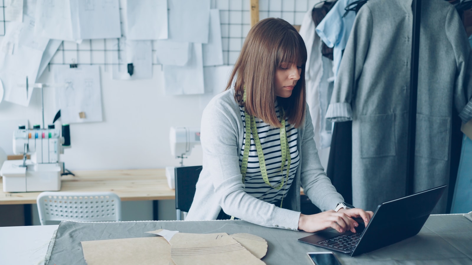 Fashion designer working on a laptop in an atelier